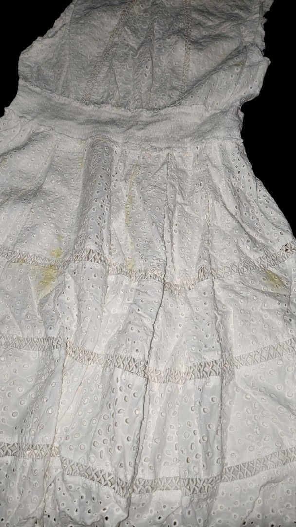 Cottagecore eyelet sleeveless mini dress (Category: Dresses) located in Quezon City. Submitted by morningstar_52 (Listing ID 1471035527, Image 2). Description: -size s-m Style: Sleeveless white dress with high neckline and back closure - Details: Eyelet embroidery, tiered skirt panels, and smocked elastic waistband - Material: 100% cotton with all-over floral cutouts - Flaws: Multiple yellow stains near the lower front skirt area (needs washing/s