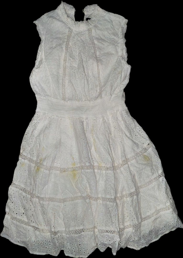 Cottagecore eyelet sleeveless mini dress (Category: Dresses) located in Quezon City. Submitted by morningstar_52 (Listing ID 1471035527, Image 3). Description: -size s-m Style: Sleeveless white dress with high neckline and back closure - Details: Eyelet embroidery, tiered skirt panels, and smocked elastic waistband - Material: 100% cotton with all-over floral cutouts - Flaws: Multiple yellow stains near the lower front skirt area (needs washing/s