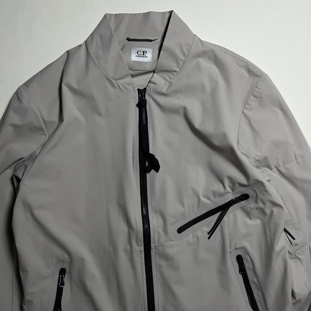 C.P. Company Pro-Tek Bomber Jacket Grey (Category: Coats, Jackets and Outerwear) located in Caloocan City. Submitted by achilles_grails (Listing ID 1471051093, Image 2). Description: - Brand: C.P. Company - Model: Pro-Tek Technical Jacket - Color: Light grey with black zippers and pull tabs - Storage: Multiple secure zipped pockets on chest, body, and sleeve - Closure: Full front zip - Details: Signature branding tags stitched inside near the col