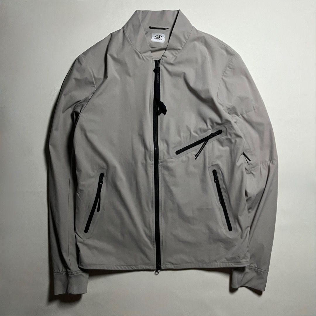 C.P. Company Pro-Tek Bomber Jacket Grey (Category: Coats, Jackets and Outerwear) located in Caloocan City. Submitted by achilles_grails (Listing ID 1471051093, Image 1). Description: - Brand: C.P. Company - Model: Pro-Tek Technical Jacket - Color: Light grey with black zippers and pull tabs - Storage: Multiple secure zipped pockets on chest, body, and sleeve - Closure: Full front zip - Details: Signature branding tags stitched inside near the col