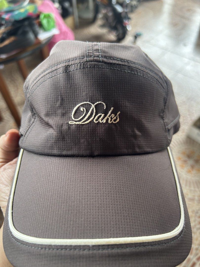 DAKS Golf Brown Cap with Plaid Strap (Category: Caps & Hats) located in Ibaan. Submitted by pathyfindsph (Listing ID 1470976694, Image 1). Description: - Authentic DAKS golf cap from Japan - Color: Brown with white piping on the brim - Embroidered DAKS logo on the front - Adjustable back strap featuring the classic DAKS plaid pattern and metal buckle - Inner mesh lining for maximum breathability - Size: F (Free size).
