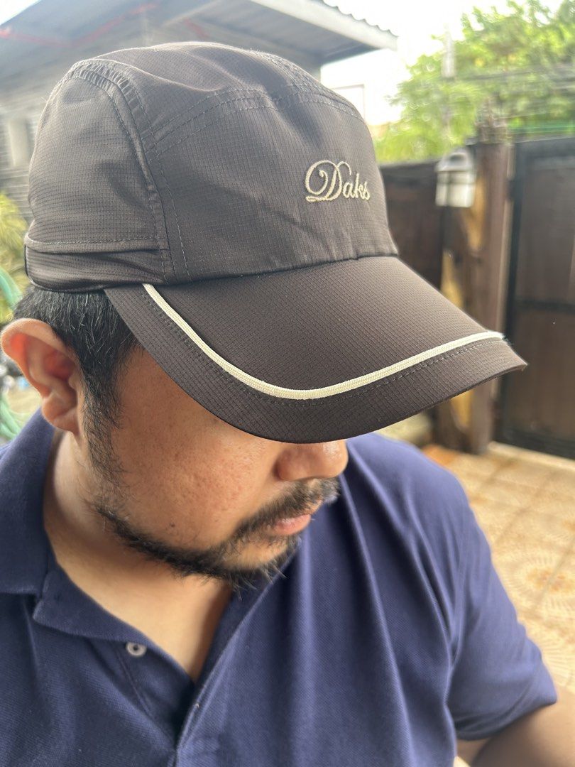 DAKS Golf Brown Cap with Plaid Strap (Category: Caps & Hats) located in Ibaan. Submitted by pathyfindsph (Listing ID 1470976694, Image 2). Description: - Authentic DAKS golf cap from Japan - Color: Brown with white piping on the brim - Embroidered DAKS logo on the front - Adjustable back strap featuring the classic DAKS plaid pattern and metal buckle - Inner mesh lining for maximum breathability - Size: F (Free size).
