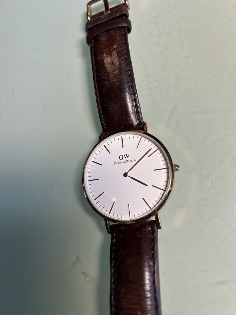 Daniel Wellington Classic Watch Dark Brown Leather Strap (Category: Men's Watches) located in Cavite. Submitted by mamamia73 (Listing ID 1471082262, Image 2). Description: - Brand: Daniel Wellington - Case Size: 40 (measured) - Color: Rose gold case with a clean white dial - Strap: Dark brown genuine leather (Note: shows heavy wear and creasing near the top buckle area) - Design: Classic minimalist face with simple line markers - Details: Brand t