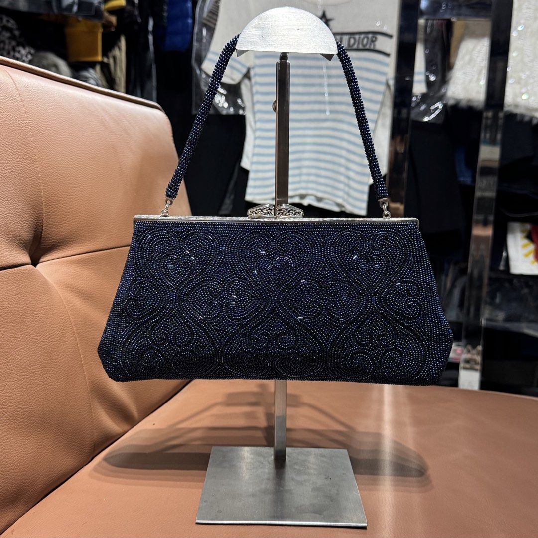 Dark Blue Beaded handmade Evening Clutch Bag with Strap (Category: Clutches) located in Rizal. Submitted by houseofbell (Listing ID 1471100235, Image 1). Description: - Color: Dark blue with intricate swirl beadwork - Hardware: Silver-tone kiss-lock clasp - Handle: Single beaded top handle - Interior: Vibrant blue satin lining with convenient slip pockets - Shape: Structured trapezoid - Condition: Excellent, ready for your next special occasion! 