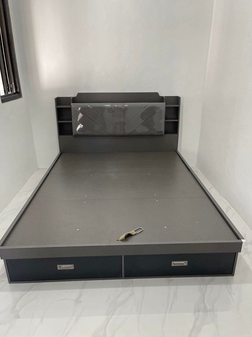 Dark Grey Storage Bed Frame with Headboard and Drawers (Category: Bed Frames & Mattresses) located in Calamba. Submitted by missarc (Listing ID 1471067546, Image 1). Description: Dark grey wooden bed frame featuring hydraulic lift storage underneath. Headboard built with upholstered padded cushion and side shelving compartments. Two pull-out drawers integrated at the foot of the base. Clean dark wood finish throughout. Mattress not included..