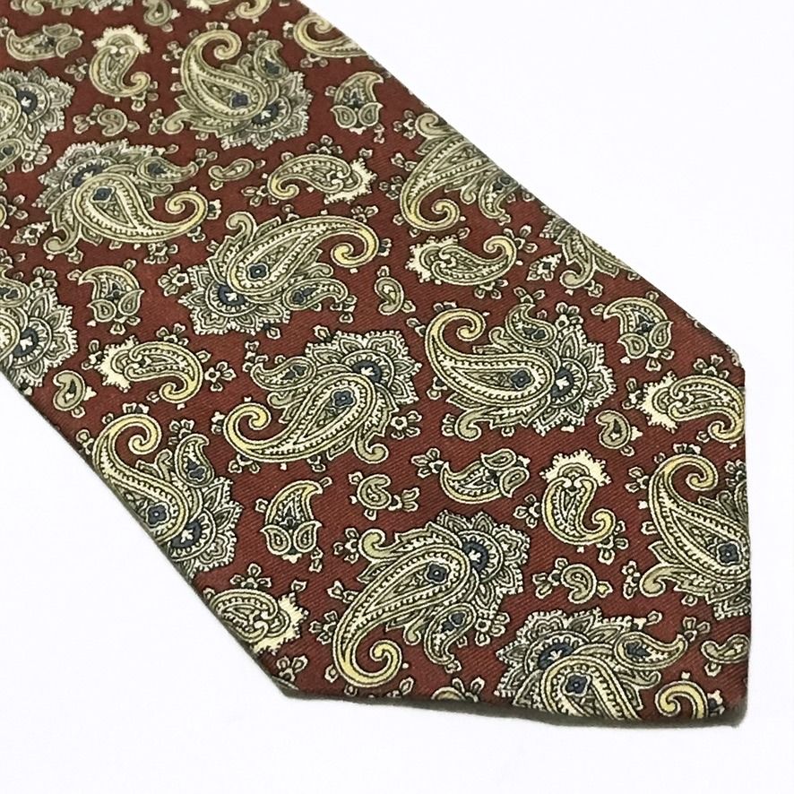 DAS Cravatte Red Paisley Neck Tie (Category: Ties) located in Taguig. Submitted by retrogaze (Listing ID 1470986622, Image 2). Description: This vintage 100% silk necktie by DAS Cravatte features a rich rust-red base woven in a subtle horizontal repp texture. The entire blade is adorned with an intricate, dense paisley foulard pattern showcasing swirling teardrop motifs and floral flourishes in soft champagne gold, cream, slate blue, and sage gre