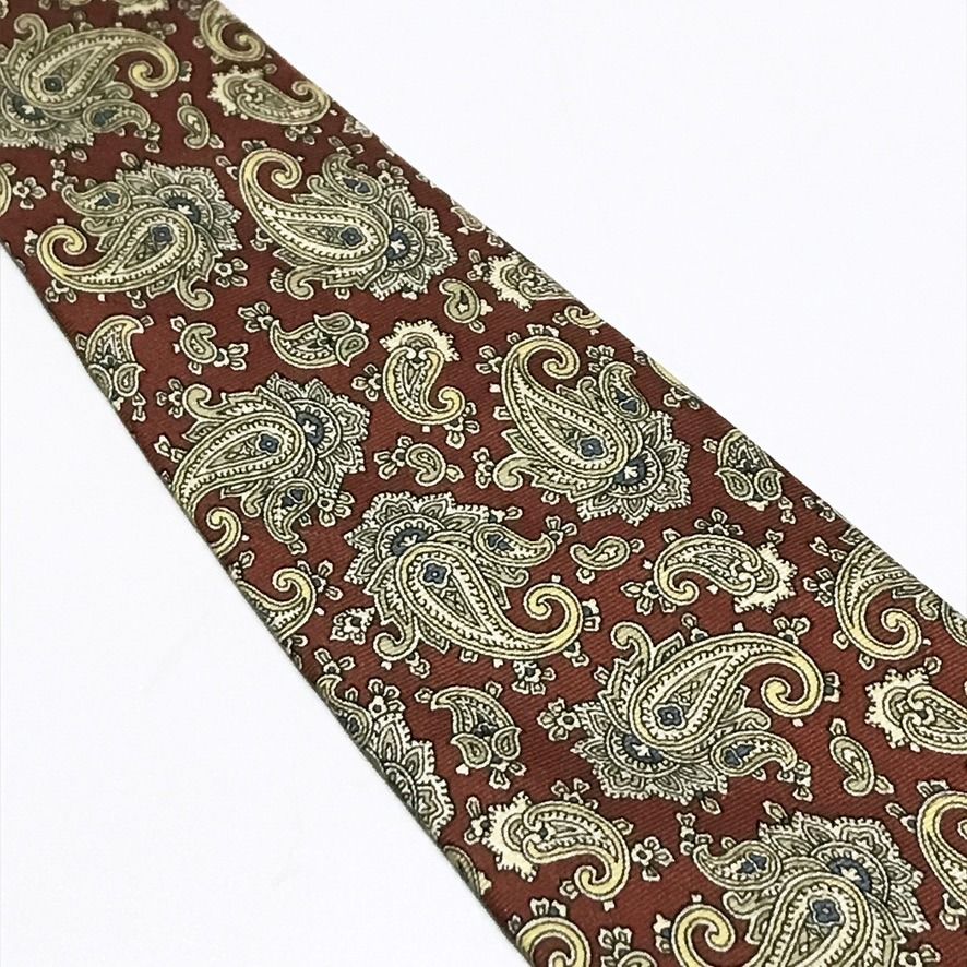 DAS Cravatte Red Paisley Neck Tie (Category: Ties) located in Taguig. Submitted by retrogaze (Listing ID 1470986622, Image 3). Description: This vintage 100% silk necktie by DAS Cravatte features a rich rust-red base woven in a subtle horizontal repp texture. The entire blade is adorned with an intricate, dense paisley foulard pattern showcasing swirling teardrop motifs and floral flourishes in soft champagne gold, cream, slate blue, and sage gre