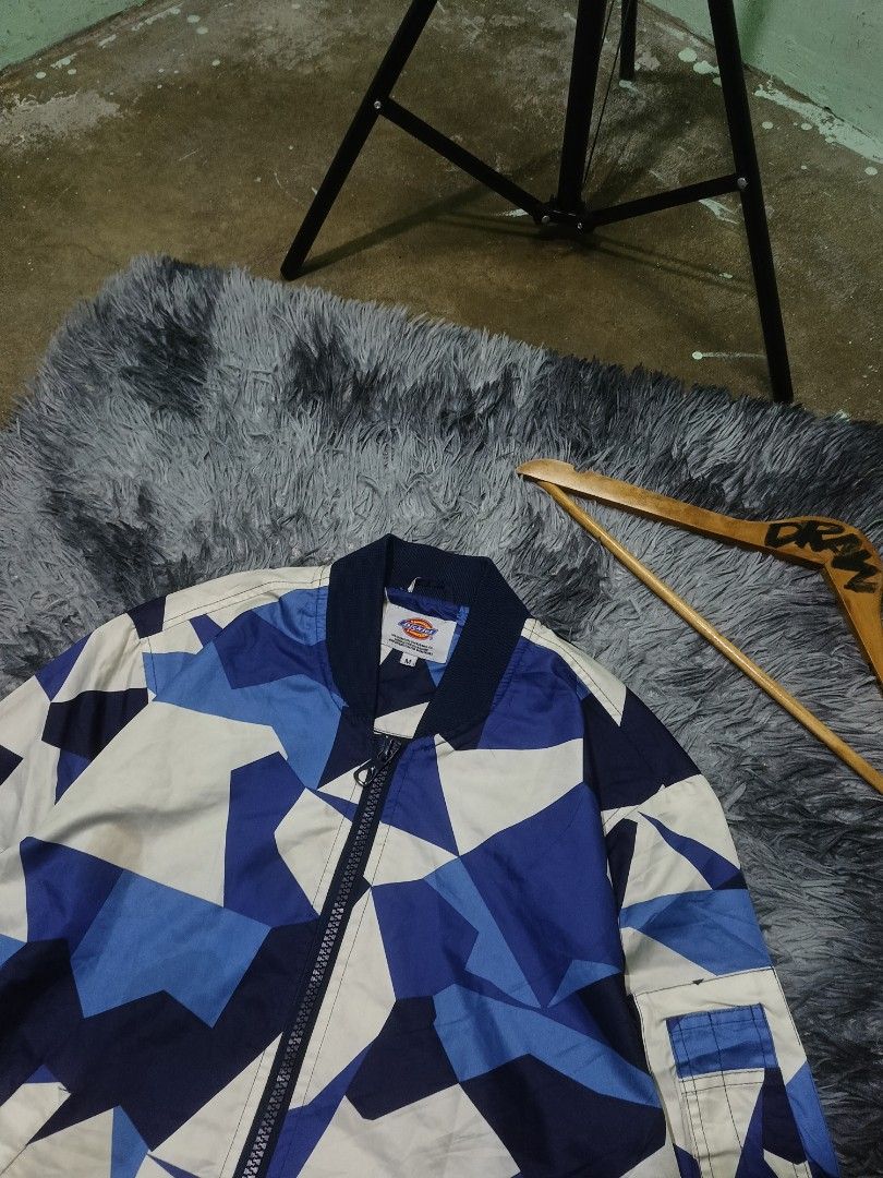 Dickies Blue Geometric Camou Bomber Jacket Size M (Category: Coats, Jackets and Outerwear) located in Las Pinas. Submitted by jowardbemi21707 (Listing ID 1471094194, Image 2). Description: Dickies bomber jacket in blue, white, and dark blue geometric camo pattern. Zip-up front, ribbed cuffs and hem. Extra zip pocket on the left sleeve with a small woven logo tag. Size M tag on the collar..