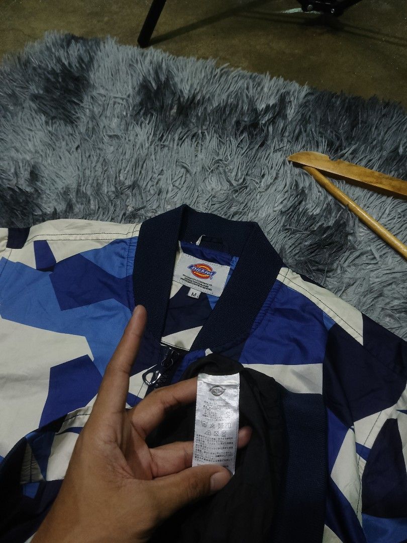 Dickies Blue Geometric Camou Bomber Jacket Size M (Category: Coats, Jackets and Outerwear) located in Las Pinas. Submitted by jowardbemi21707 (Listing ID 1471094194, Image 3). Description: Dickies bomber jacket in blue, white, and dark blue geometric camo pattern. Zip-up front, ribbed cuffs and hem. Extra zip pocket on the left sleeve with a small woven logo tag. Size M tag on the collar..