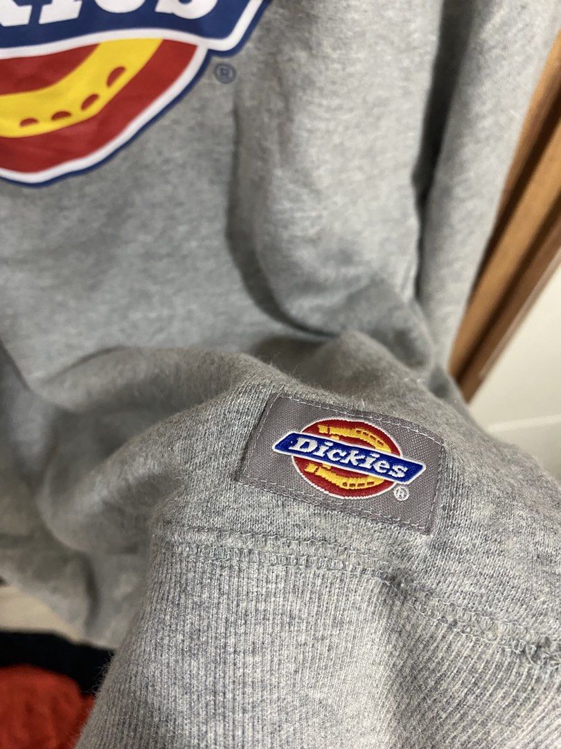 Dickies Grey Sweatshirt Size S (Category: Coats, Jackets and Outerwear) located in Caloocan City. Submitted by heatedcaps4425 (Listing ID 1471098196, Image 2). Description: - Brand: Dickies - Color: Grey - Size: Small - Design: Large chest logo graphic with iconic Williamson-Dickies tagging - Details: Ribbed collar, cuffs, and hem for a snug fit - Accents: Small branded patch near the bottom hem and inner neck taping with repeating logo text - Co