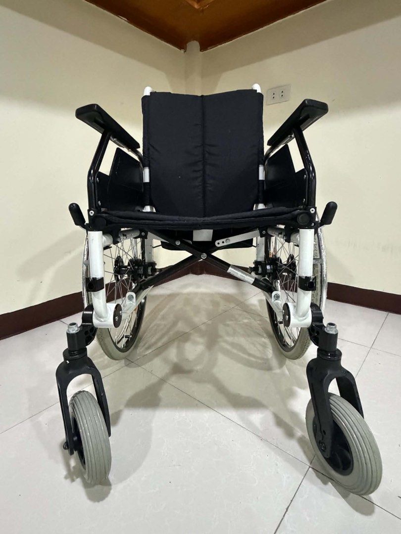 Dietz CANEO-E Wheelchair (Category: Wheelchairs) located in Manila. Submitted by calmdolphin.87b0e4 (Listing ID 1470960042, Image 3). Description: Dietz CANEO-E lightweight folding wheelchair. Black fabric seat and backrest with branding on the rear. White metal frame, grey pneumatic tires, sturdy push handles, and adjustable footrests included. Clean condition, works smoothly, easy to transport..