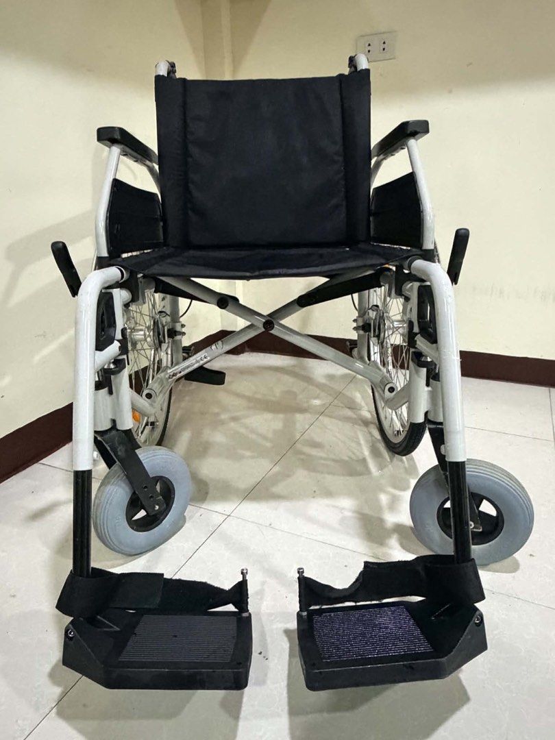 Dietz CANEO-E Wheelchair (Category: Wheelchairs) located in Manila. Submitted by calmdolphin.87b0e4 (Listing ID 1470960042, Image 1). Description: Dietz CANEO-E lightweight folding wheelchair. Black fabric seat and backrest with branding on the rear. White metal frame, grey pneumatic tires, sturdy push handles, and adjustable footrests included. Clean condition, works smoothly, easy to transport..