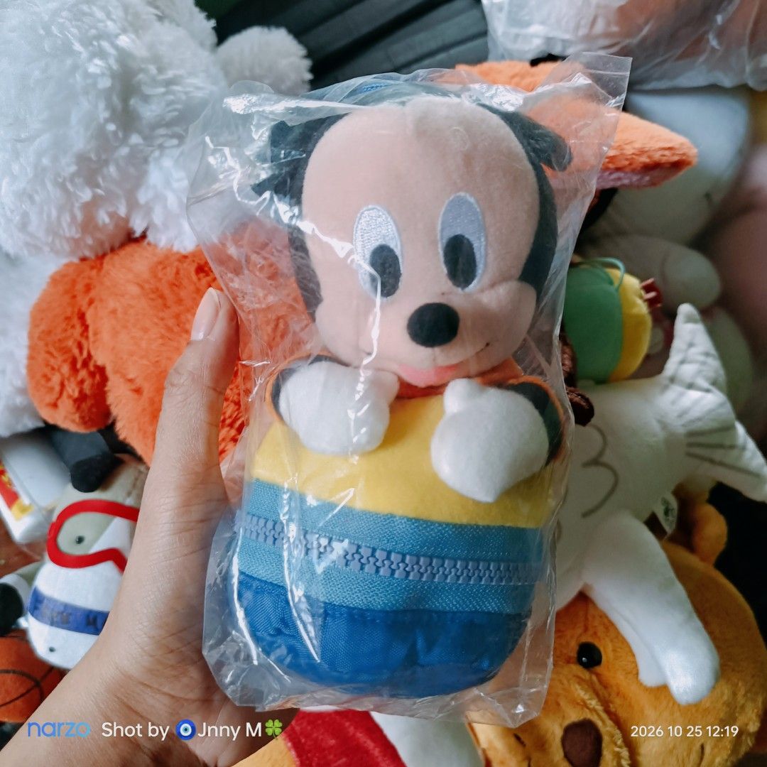 Disney Mickey Mouse plush toy pouch with strap (Category: Plushies & Soft Toys) located in Taguig. Submitted by mhayestufftoys (Listing ID 1470968997, Image 1). Description: - Official Disney Mickey Mouse character plush pouch - Features a handy blue strap for carrying or hanging - Yellow and blue zippered pouch body for small storage - Soft fabric material with white plush gloves and friendly expression - Authentic Disney tag attached at the bac