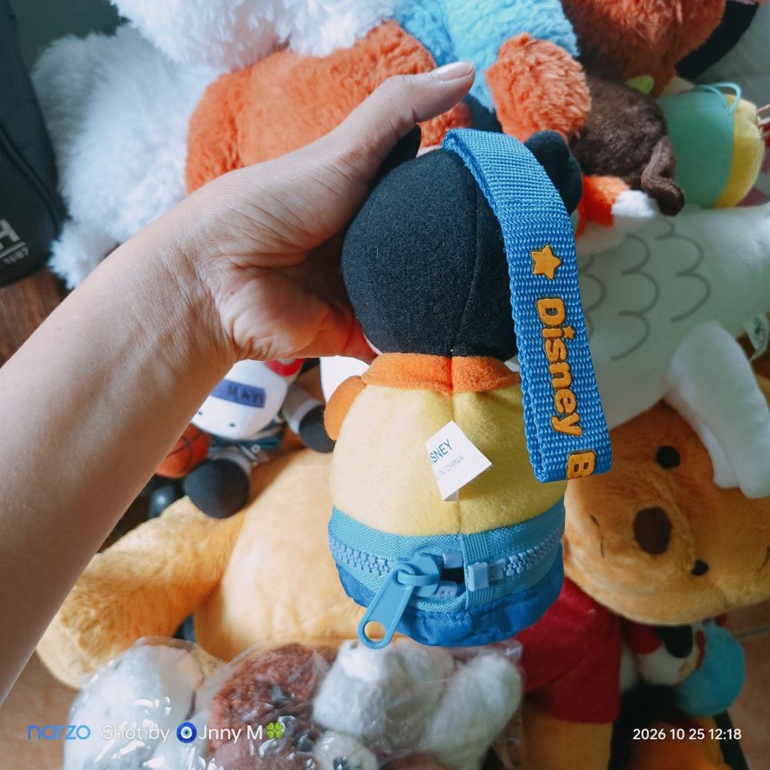 Disney Mickey Mouse plush toy pouch with strap (Category: Plushies & Soft Toys) located in Taguig. Submitted by mhayestufftoys (Listing ID 1470968997, Image 2). Description: - Official Disney Mickey Mouse character plush pouch - Features a handy blue strap for carrying or hanging - Yellow and blue zippered pouch body for small storage - Soft fabric material with white plush gloves and friendly expression - Authentic Disney tag attached at the bac