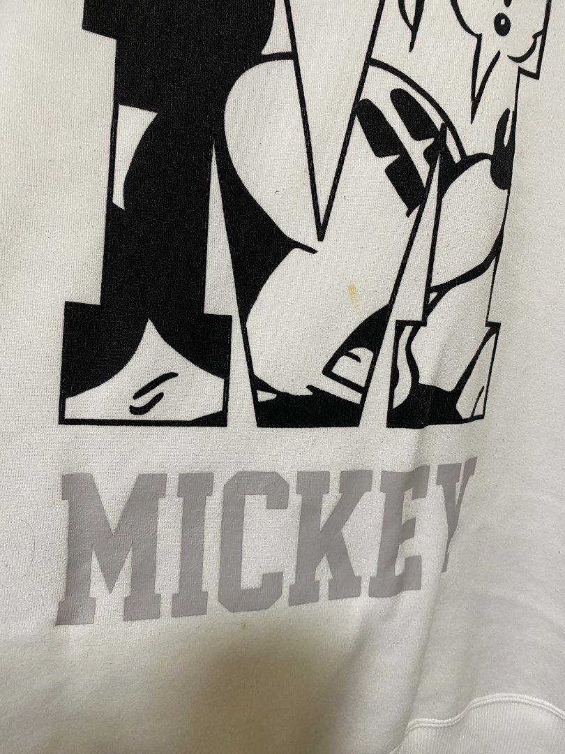 Disney Mickey Mouse White Sweatshirt (Category: Coats, Jackets and Outerwear) located in Silang. Submitted by iamjhestine (Listing ID 1471070344, Image 2). Description: - Authentic Disney Mickey Mouse sweatshirt in white - Features a large graphic print inside the letter 'M' with 'MICKEY' lettering - Cozy soft fleece interior lining - Classic ribbed crewneck, cuffs, and hem - Flaw: Noticeable small yellow stain near the bottom of the graphic prin