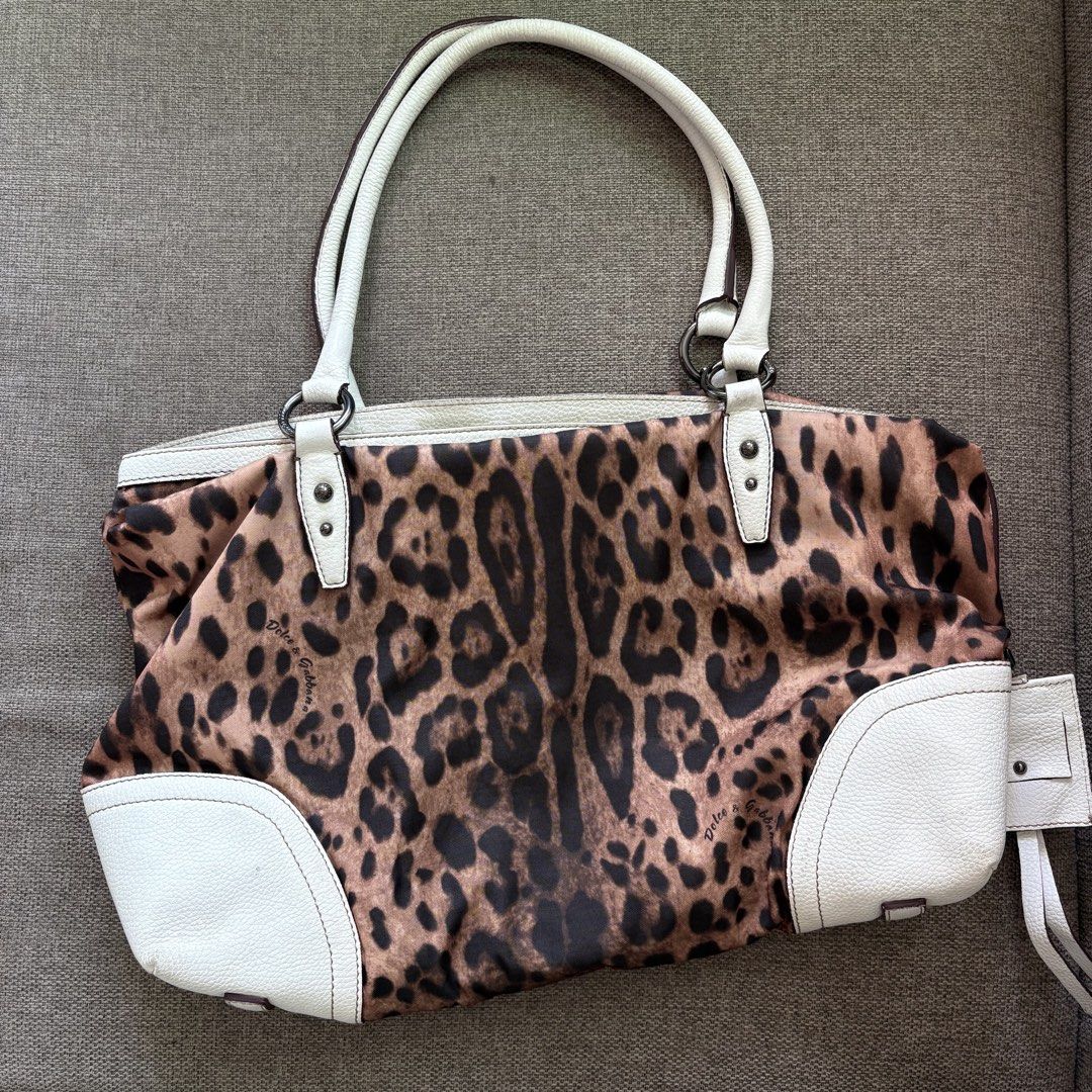 Dolce & Gabbana Leopard Print Maxi Tote Bag (Category: Tote Bags) located in Bacolod City. Submitted by ayenkhey (Listing ID 1471047367, Image 2). Description: - Authentic Dolce & Gabbana leopard print tote bag with white leather trim and handles - Features a large embossed logo patch on the front - Secure zip closure with brown fabric lining and interior zip pocket - Crafted in Italy - Condition: Normal signs of use around the leather corners an