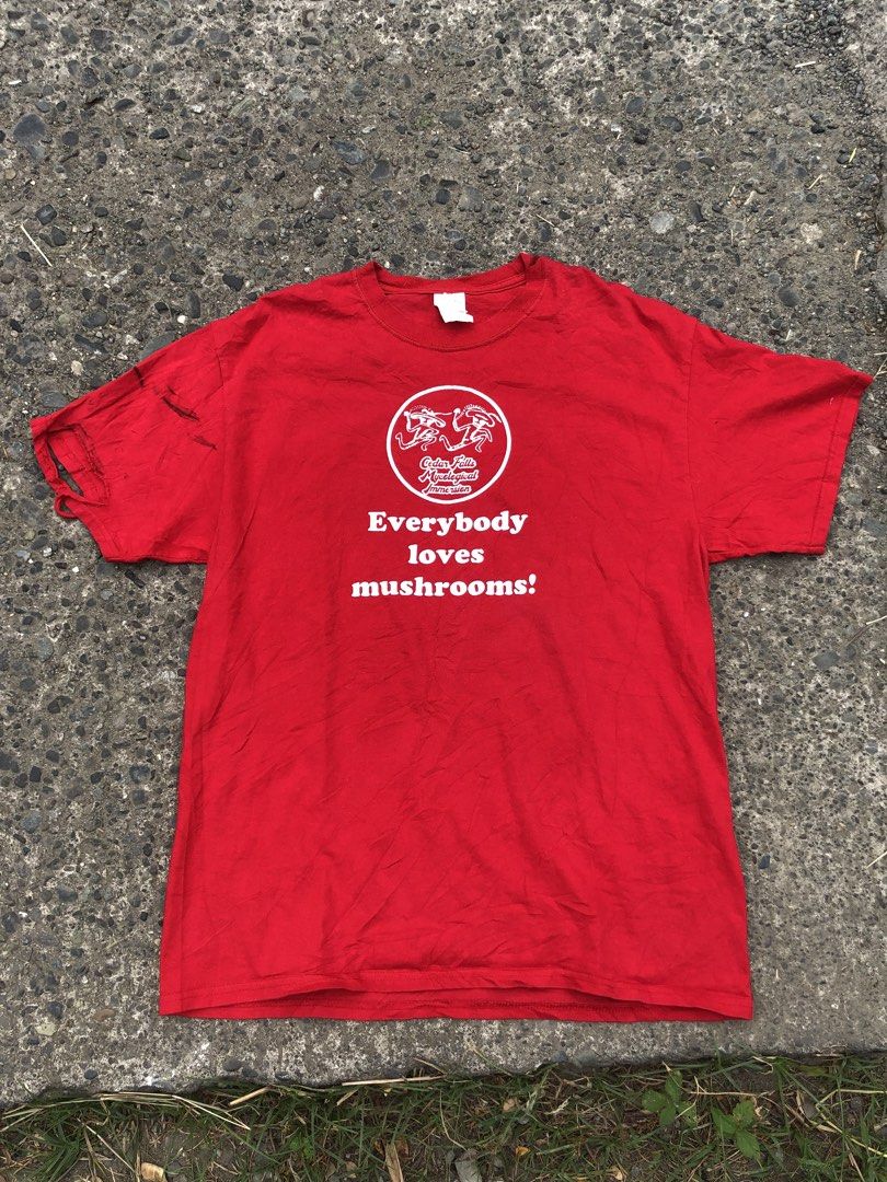 Everybody loves mashrooms (Category: Tshirts & Polo Shirts ) located in San Jose. Submitted by mightycloud-7dc0 (Listing ID 1470976283, Image 1). Description: - Brand/Style: Port & Company bright red graphic t-shirt - Size: Large - Design: Front circle logo reads 'Cedar Falls Mycological Immersion' with 'Everybody loves mushrooms' underneath - Origin: Made in Honduras - Flaws: Noticeable dark ink stains and fabric tears near the right sleeve hem 