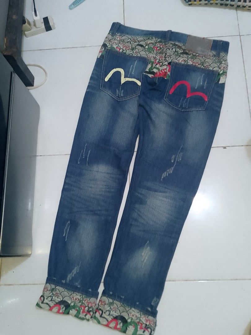 EVISU (INSPIRED) SLIM STRAIGHT JEANS (Category: Jeans) located in Binan City. Submitted by jov_abii (Listing ID 1470948848, Image 2). Description: - Size: 31 - Fit: Relaxed streetwear - Design: Distressed details with front whiskers - Unique accents: Patterned fabric on waistband and rolled cuffs - Pockets: Two back pockets with yellow and pink embroidered gullwing designs DIMENSIONS 📐(INCHES) WAIST 31 LENGTH: 42 (UNCUFFED) 38 (CUFFED) THIGHS: 1