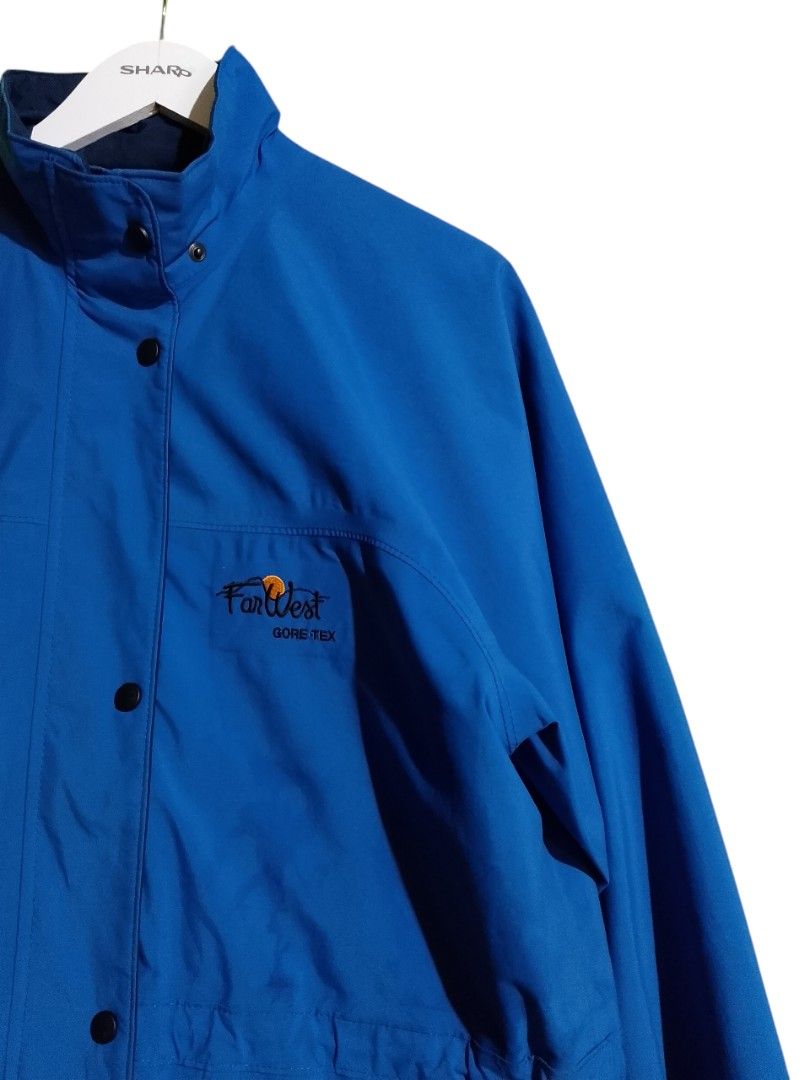FarWest Gore-Tex Blue Waterproof Windbreaker Jacket (Category: Coats, Jackets and Outerwear) located in Baler. Submitted by vansonearth (Listing ID 1470971004, Image 3). Description: Bright blue FarWest Gore-Tex jacket. Embroidered logo on the chest. Full zip front with snap button storm flap. Two large lower flap pockets and an inner zippered pocket. Drawstrings at the waist and hem to adjust fit. Navy interior lining and collar..