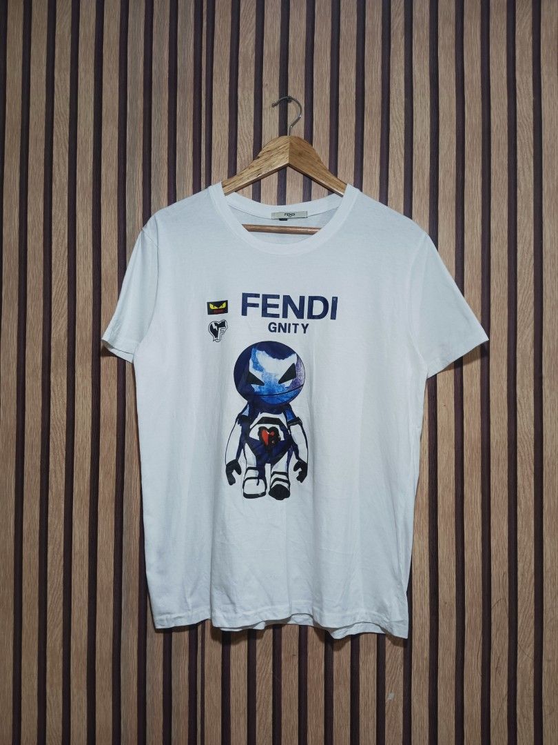 Fendi Gnity Robot Graphic White T-Shirt (Category: Shirts) located in Manila. Submitted by delavinjor93182 (Listing ID 1471114791, Image 1). Description: - Brand: Fendi - Color: White with blue robot graphic - Key Features: Iconic monster eyes patch and heart chest accent - Details: Crew neck, short sleeves, straight hem, Fendi Roma collar tag - Condition: Clean and crisp.