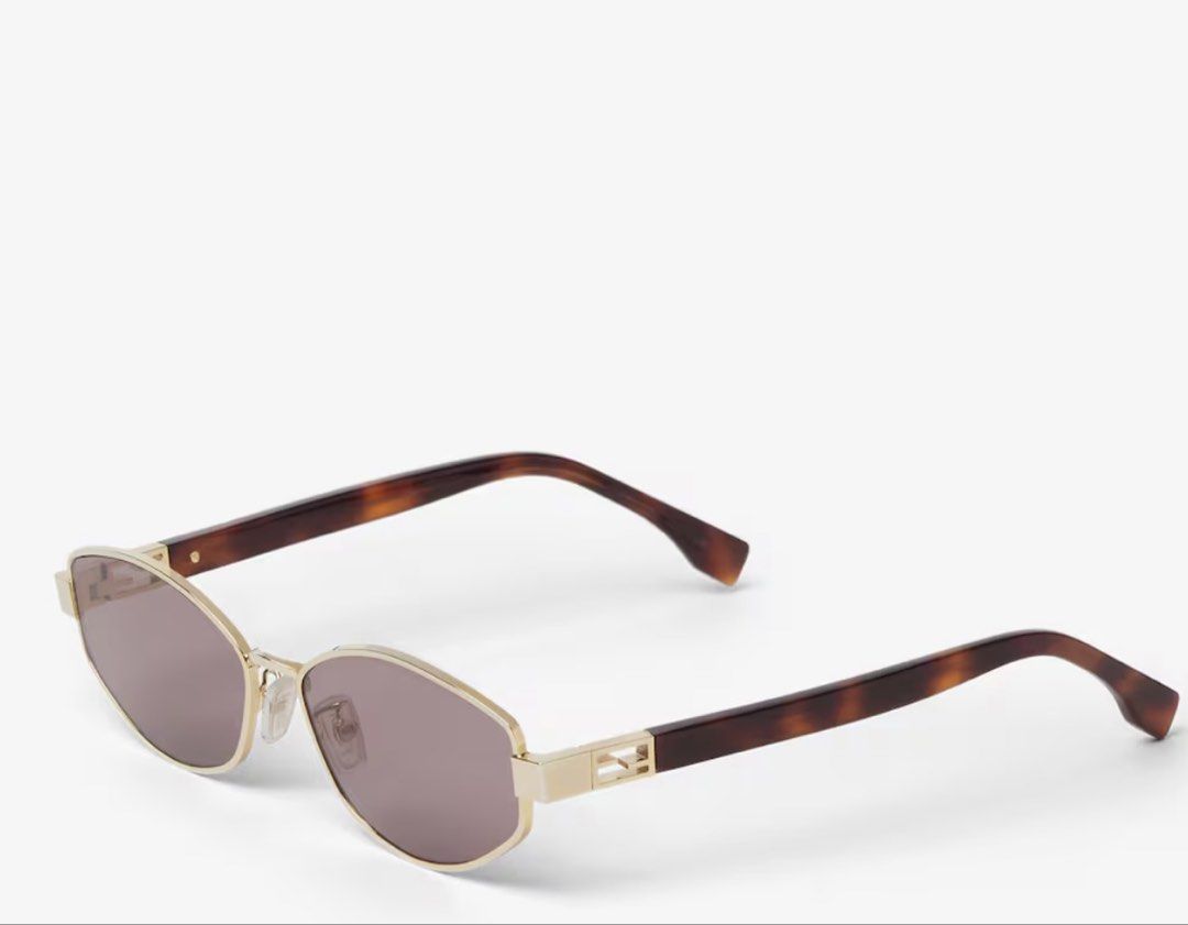 Fendi Sunglasses Brown (Category: Sunglasses & Eyewear) located in Makati City. Submitted by xoxonisse (Listing ID 1470999766, Image 2). Description: - Brand: Fendi - Model: Tube Sunglasses - Frame: Sleek geometric shape in gold-coloured metal and acetate - Lenses: Brown lenses with stylish tortoise-pattern temples - Details: Iconic FF logo on the side hinge - Condition: Brand new / Excellent (used once only) - Ideal for: Everyday wear, driving, 