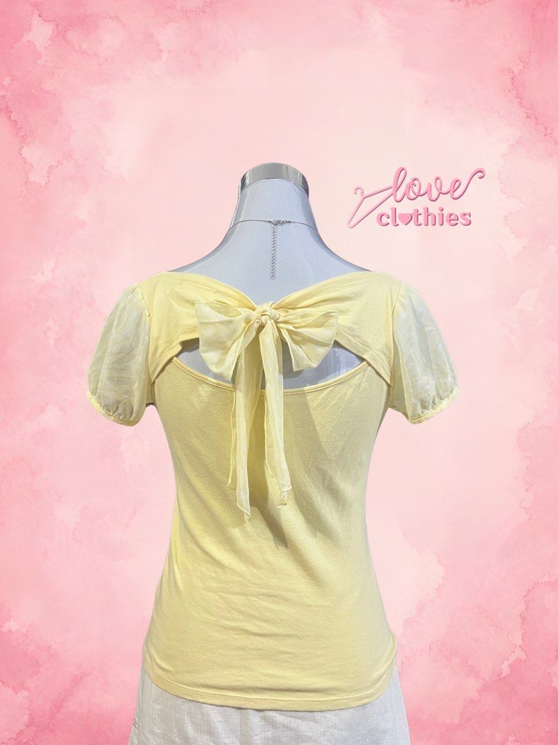 Feroux Yellow Short Sleeve Bow Back Top (Category: Blouses) located in Tuguegarao City. Submitted by love_clothies (Listing ID 1471068942, Image 2). Description: - Brand: Feroux - Color: Yellow - Style: Short sleeve top with scoop neckline - Details: Sheer puff sleeves with subtle dot pattern and large open-back bow tie - Material: Comfortable cotton body with polyester contrast - Fit: Relaxed and comfortable - Origin: Made in China.