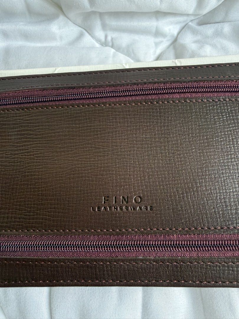 Fino Leatherware (Category: Wallets & Card holders) located in Pasig City. Submitted by weng0952 (Listing ID 1471027983, Image 2). Description: - Brand: Fino Leatherware - Color: Burgundy( red wine)with quality textured leather construction - Storage: Multiple exterior zippered pockets, interior card slots, and main cash compartment - Inclusions: Comes with original white presentation box - Condition: Excellent, well-maintained - Shipping: Fast s