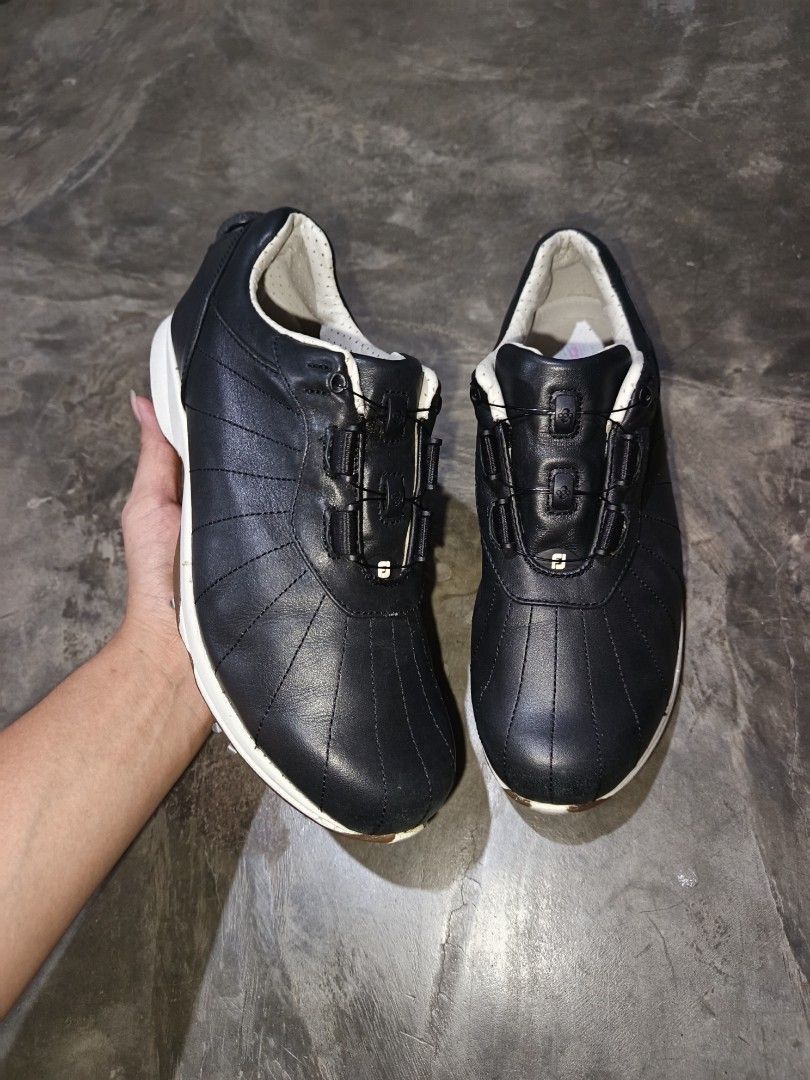 FootJoy Black Golf Shoes with Spikes (Category: Golf) located in Davao. Submitted by judethrifter (Listing ID 1471078167, Image 2). Description: FootJoy golf shoes in black leather. Dial lacing system across the top for quick tightening. White and brown outsoles fitted with Softspikes metal studs for traction on the course. Padded inner collar around the ankle. Solid grip underneath. Ready for the next round..