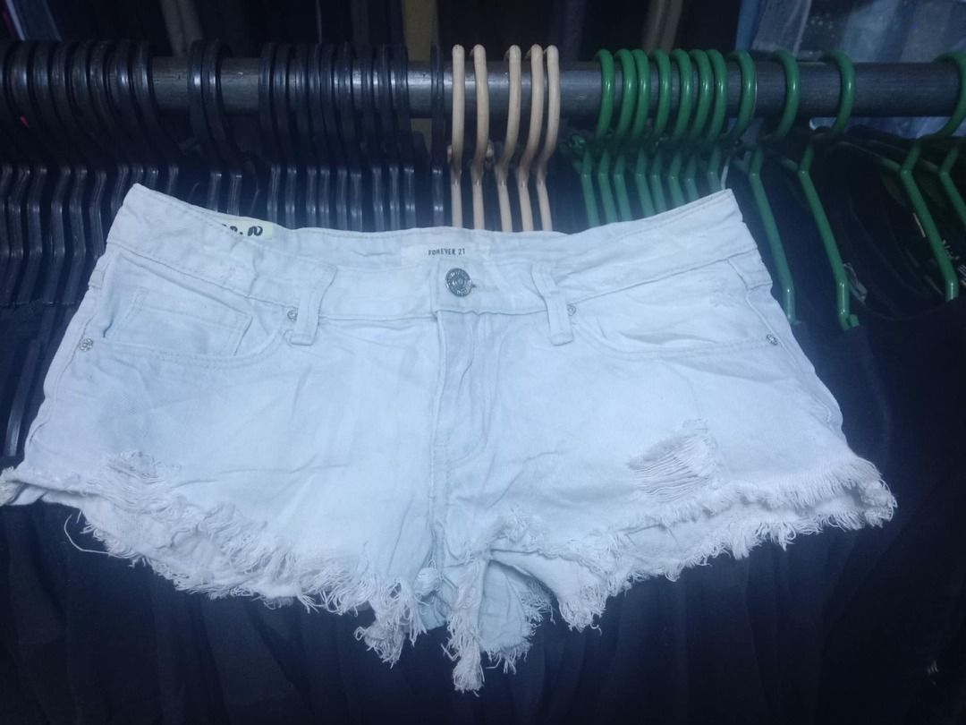 Forever 21 White Distressed Denim Shorts Size 24 (Category: Shorts) located in Quezon City. Submitted by honeyonline.ph (Listing ID 1471047220, Image 2). Description: - Brand: Forever 21 - Size: 24 - Color: Light wash white denim - Style: Raw hem with frayed edges and front distressed details - Design: Classic five-pocket styling with button and zip fly closure - Origin: Made in Pakistan - Condition: Excellent pre-loved or brand new (ready to wea