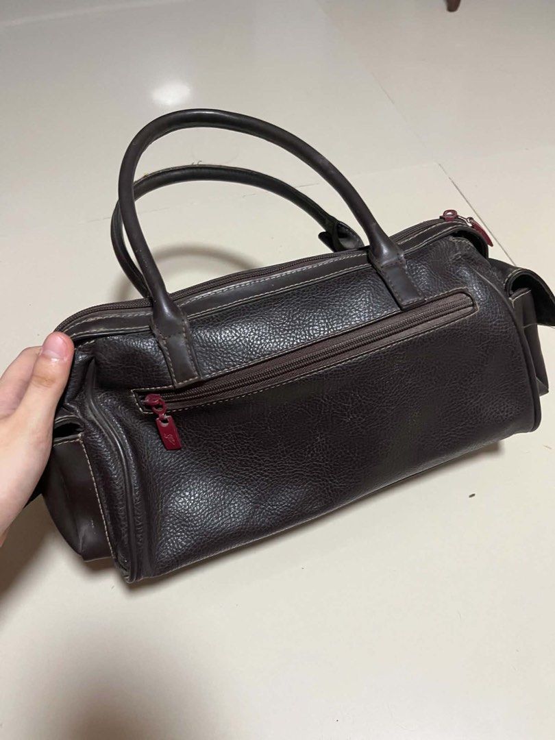 Fortune Duck Collection Brown Leather Handbag (Category: Luxury Bags & Wallets) located in General Trias. Submitted by starberrii (Listing ID 1470978181, Image 3). Description: - Brand/Collection: Fortune Duck Collection - Color/Material: Dark brown leather with fabric lining - Design: Structured everyday handbag with dual top handles - Closure & Pockets: Decorative red lock front pocket and multiple zipped compartments inside and out - Condition