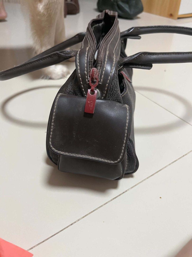 Fortune Duck Collection Brown Leather Handbag (Category: Luxury Bags & Wallets) located in General Trias. Submitted by starberrii (Listing ID 1470978181, Image 2). Description: - Brand/Collection: Fortune Duck Collection - Color/Material: Dark brown leather with fabric lining - Design: Structured everyday handbag with dual top handles - Closure & Pockets: Decorative red lock front pocket and multiple zipped compartments inside and out - Condition