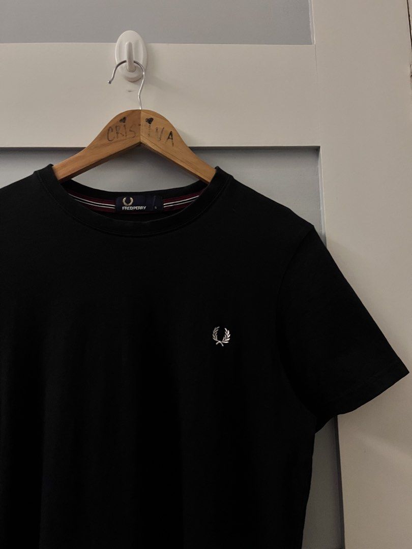 Fred Perry Black T-Shirt Size S (Category: Tshirts & Polo Shirts ) located in Calasiao. Submitted by cristinabarongan5 (Listing ID 1471058759, Image 2). Description: Black crew neck t-shirt from Fred Perry. Size S fits true to size. Classic laurel wreath embroidery on the chest in white. Tipped collar detail with burgundy and white stripes. Made in China, 100% cotton material. Clean inside tags and clear branding at the neck label. Great basic pi