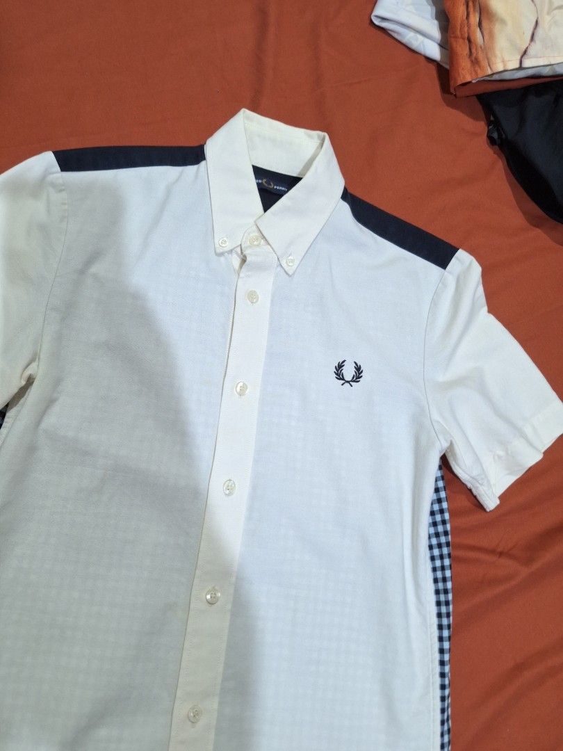 Fred Perry Short Sleeve Button Down Shirt XS (Category: Tshirts & Polo Shirts ) located in Manila. Submitted by adolphreyes645 (Listing ID 1471059407, Image 2). Description: - Brand: Fred Perry - Size: XS - Style: Short-sleeve button-down shirt - Design: White front with navy shoulder yoke and blue/white gingham check back - Details: Embroidered laurel wreath logo on the chest, collared neck - Condition: Pre-loved with noticeable yellowing on the