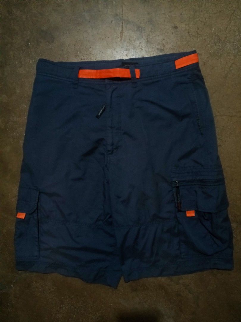 FUBU Blue Cargo Shorts Size XL 36 (Category: Shorts) located in Cavite. Submitted by markyzz_19 (Listing ID 1471084745, Image 1). Description: - Brand: FUBU - Color: Navy blue with orange accent details - Size: XL (fits size 36) - Pockets: Multiple utility pockets including cargo side pockets and rear flap pockets - Details: Embroidered logos and high-quality fabric construction - Style: Relaxed streetwear fit.