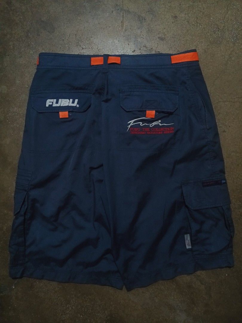 FUBU Blue Cargo Shorts Size XL 36 (Category: Shorts) located in Cavite. Submitted by markyzz_19 (Listing ID 1471084745, Image 2). Description: - Brand: FUBU - Color: Navy blue with orange accent details - Size: XL (fits size 36) - Pockets: Multiple utility pockets including cargo side pockets and rear flap pockets - Details: Embroidered logos and high-quality fabric construction - Style: Relaxed streetwear fit.