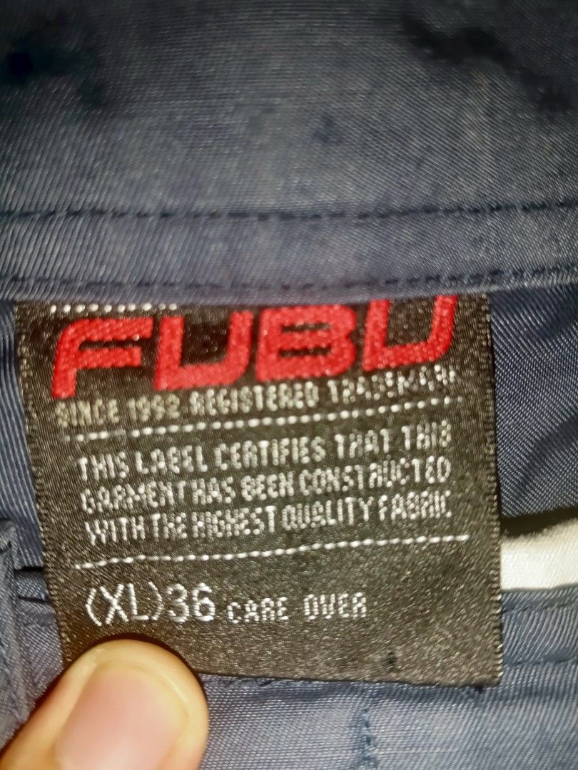 FUBU Blue Cargo Shorts Size XL 36 (Category: Shorts) located in Cavite. Submitted by markyzz_19 (Listing ID 1471084745, Image 3). Description: - Brand: FUBU - Color: Navy blue with orange accent details - Size: XL (fits size 36) - Pockets: Multiple utility pockets including cargo side pockets and rear flap pockets - Details: Embroidered logos and high-quality fabric construction - Style: Relaxed streetwear fit.