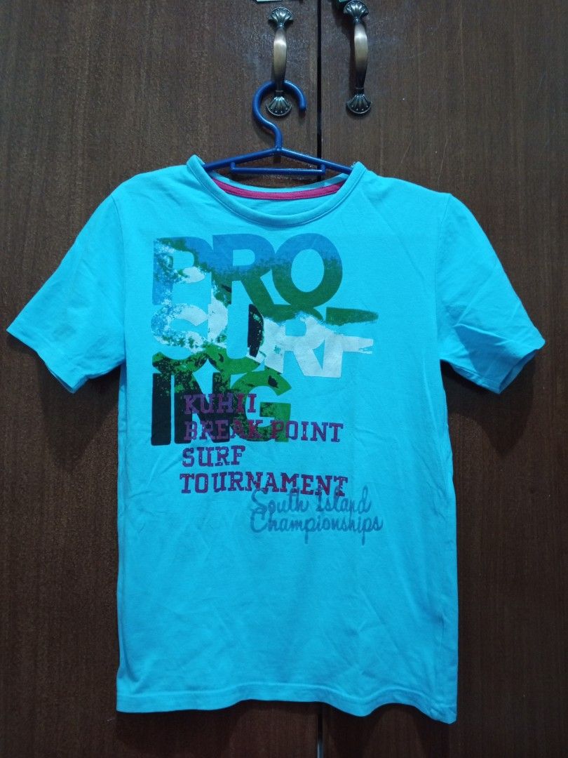 George T-Shirt for Kids (Category: Babies & Kids Fashion) located in Manila. Submitted by clariz76 (Listing ID 1471002609, Image 1). Description: Bright turquoise blue t-shirt featuring a large graphic print on the front with surf tournament text details. Crew neck design with short sleeves and a plain solid back. Vibrant colors and fun sporty design, great casual wear..
