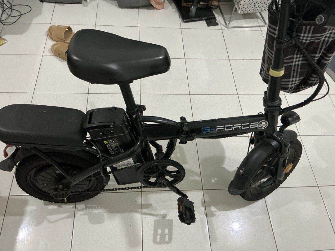 G-Force Electric Bicycle Black Foldable E-Bike (Category: Bicycles) located in Quezon City. Submitted by jbbuenafe11 (Listing ID 1471051827, Image 1). Description: - Black G-Force folding electric bicycle - Compact and easy-to-fold frame for quick storage and transport - Includes a rear passenger seat and a stylish front basket with a plaid pattern - Equipped with chain guard and functional pedals - Battery pack conveniently mounted below the mai