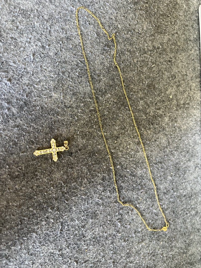 Gold Cross Pendant Necklace (Category: Necklaces) located in Cavite. Submitted by heneral11111111 (Listing ID 1471083950, Image 2). Description: - Gold-tone chain necklace with a matching cross pendant - Small sparkling stones embedded along the front of the cross - Thin link chain style for a delicate look - Easy to clasp and comfortable for daily wear - Minimal wear on the metal finish, well-maintained piece.