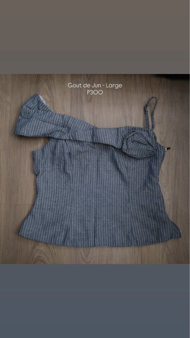 Gout de Jun Blue Striped One-Shoulder Top Large (Category: Sleeveless) located in Manila. Submitted by mixi_lexi (Listing ID 1471023288, Image 1). Description: - Brand: Gout de Jun - Size: Large - Design: One-shoulder with a thin strap and decorative fabric rosette - Pattern: Vertical white stripes on blue background - Closure: Side zipper - Quality: Neat stitching throughout, well-maintained.