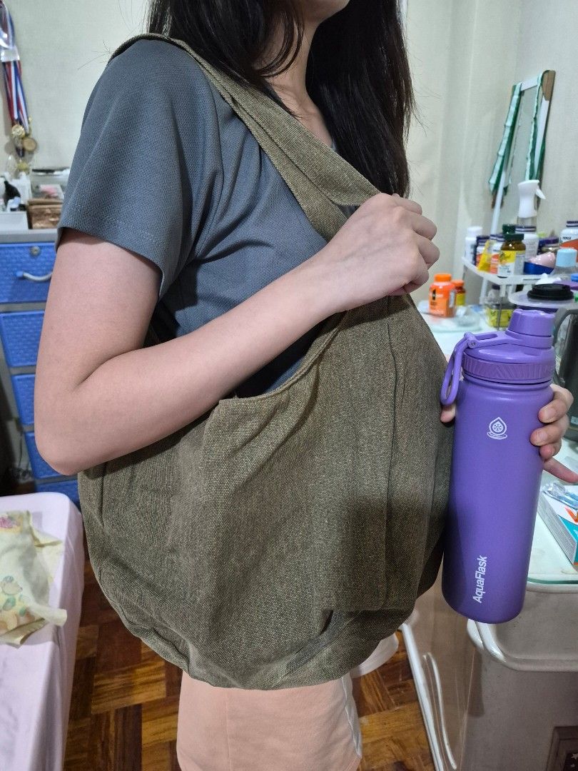 Green Canvas Tote Bag Shoulder Bag (Category: Tote Bags) located in Manila. Submitted by amazingshopper2024 (Listing ID 1471079800, Image 3). Description: - Color: Olive green with cream inner lining - Material: Sturdy canvas with strong shoulder straps - Storage: Big and roomy, easily fits a large water bottle and daily essentials - Features: Convenient zipped inner pocket for secure storage - Style: Casual everyday bag.