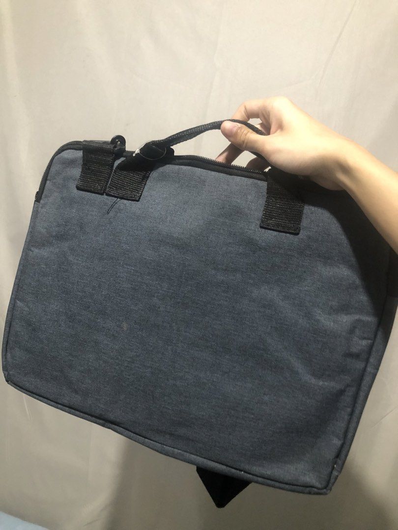 Grey Laptop Bag with Shoulder Strap (Category: Laptop Bags & Sleeves) located in General Trias. Submitted by dmcwl (Listing ID 1471053038, Image 2). Description: PRELOVED LAPTOP BAG FOR SALE! PS: Kasya po dito yung laptop na may numeric keys. RFS: May laptop bag na po akong ginagamit kaya di na din masyado nagagamit. - Color: Grey canvas with black handles - Features: Adjustable shoulder strap, secure top-zip closure, and sturdy side clips - Cond