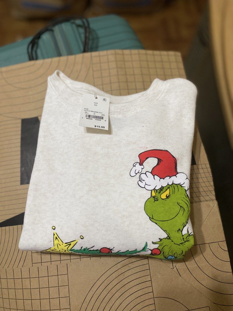 Grinch Christmas Sweatshirt Holiday Pullover White XS (Category: Babies & Kids Fashion) located in Batangas. Submitted by lux_kimmy (Listing ID 1470964542, Image 2). Description: - Item: White Grinch Holiday Sweatshirt - Size: Extra Small (XS) - Condition: Brand new with original store tags (Original retail: $15) - Design: Festive Grinch graphic with Santa hat and Christmas lights - Style: Comfortable crewneck - Perfect for holiday parties and gi