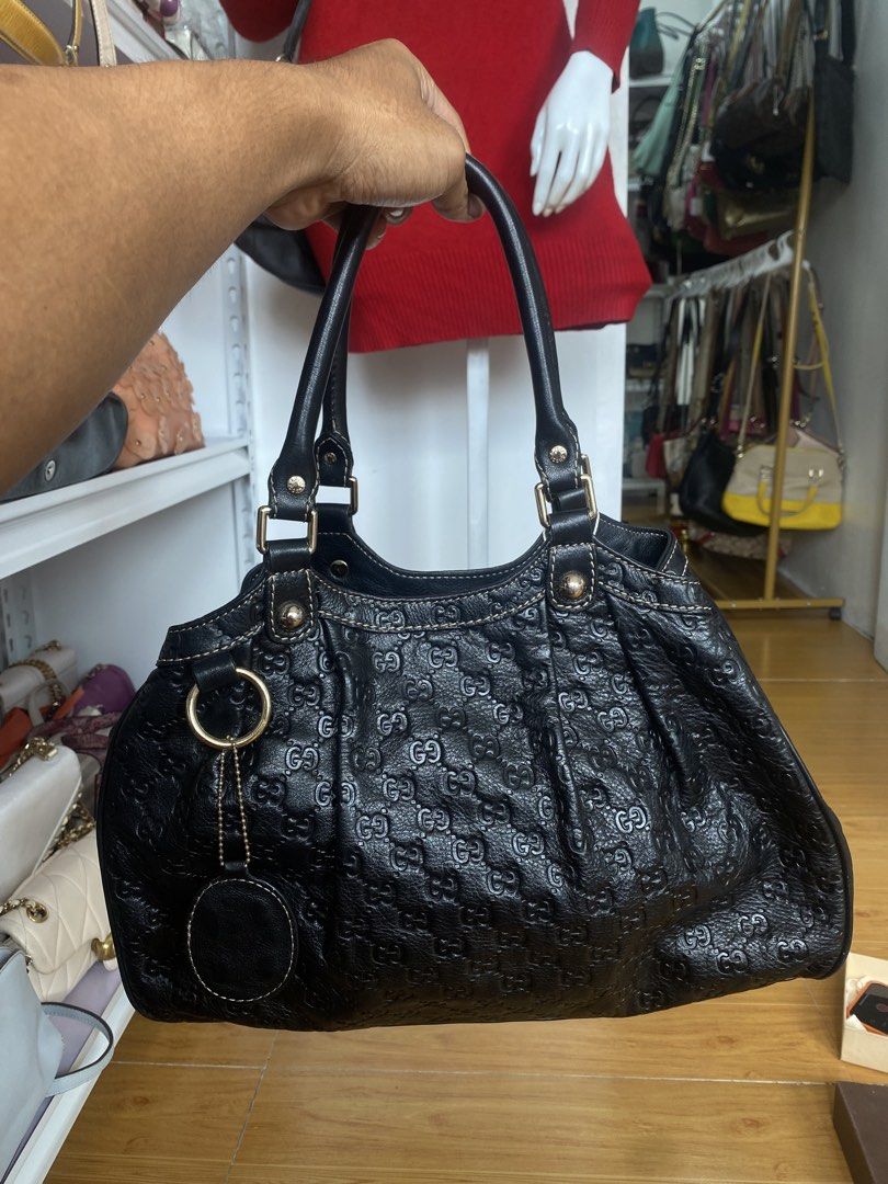 Gucci Black Monogram Leather Shoulder Bag (Category: Luxury Bags & Wallets) located in San Fernando. Submitted by thrifteezy6 (Listing ID 1470960862, Image 1). Description: - Authentic black Gucci leather shoulder bag - Classic all-over GG debossed monogram pattern - Elegant contrast white stitching and gold-tone hardware - Secure zip closure with printed interior lining - Dual structured top handles for easy carrying - Stylish side charm attache