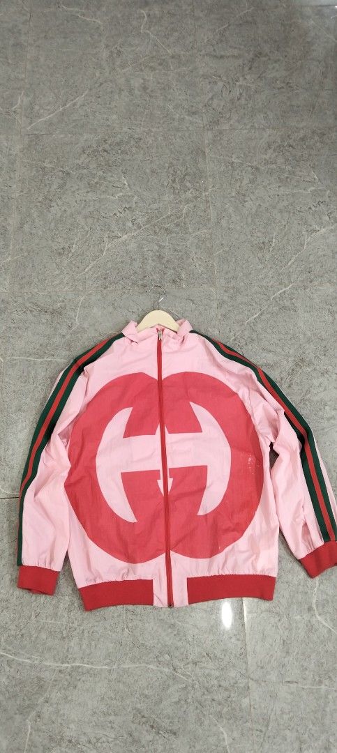 Gucci Pink Windbreaker Jacket with Interlocking G Logo (Category: Coats, Jackets and Outerwear) located in Bacolod City. Submitted by hurleydediamante0513 (Listing ID 1471014859, Image 1). Description: - Brand: Gucci - Style: Zip-up lightweight nylon windbreaker - Color: Pink with iconic red oversized G logo - Accents: Green and red web stripe detailing down both sleeves - Features: Red ribbed cuffs and hem, full front zipper with Gucci branded m
