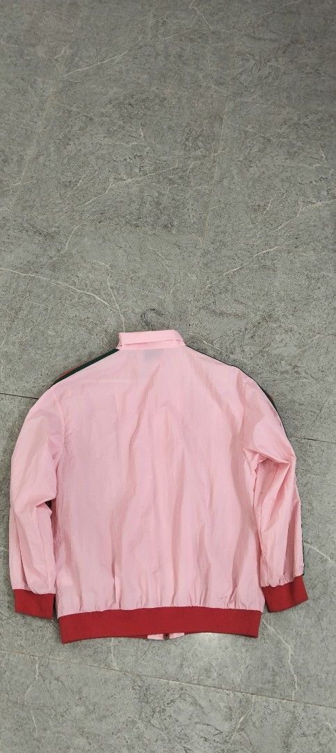 Gucci Pink Windbreaker Jacket with Interlocking G Logo (Category: Coats, Jackets and Outerwear) located in Bacolod City. Submitted by hurleydediamante0513 (Listing ID 1471014859, Image 3). Description: - Brand: Gucci - Style: Zip-up lightweight nylon windbreaker - Color: Pink with iconic red oversized G logo - Accents: Green and red web stripe detailing down both sleeves - Features: Red ribbed cuffs and hem, full front zipper with Gucci branded m