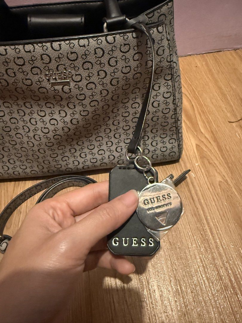 Guess Monogram Tote Bag with Crossbody Strap (Category: Luxury Bags & Wallets) located in Pasig City. Submitted by sea321 (Listing ID 1470941967, Image 2). Description: Guess tote bag in grey and black monogram print. Dual top handles plus a long detachable crossbody strap. Includes branded hanging charms and keyring tag. Magnetic snap closure on the main compartment, plus an interior zipped pocket and slip pockets. Fabric lining with Guess logo 