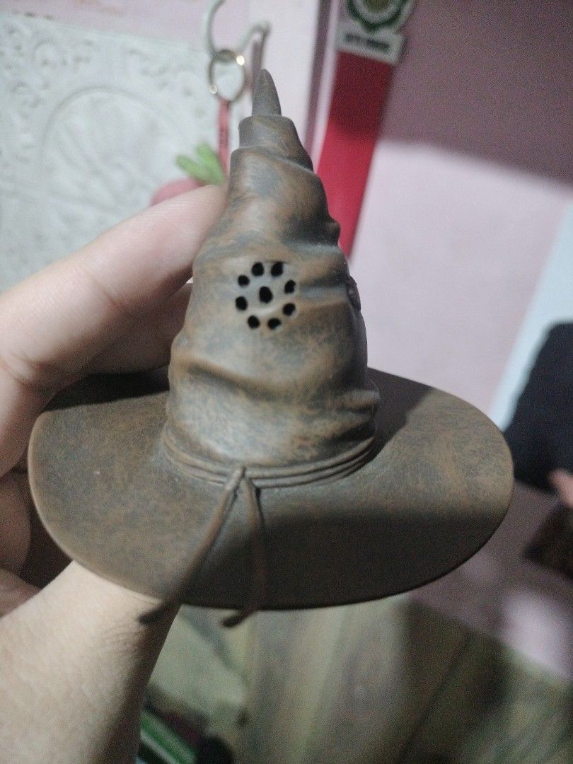 Harry Potter Sorting Hat Figurine Collectible (Category: Figurines & Statues) located in Paranaque City. Submitted by chechein_shop (Listing ID 1470966853, Image 2). Description: - Official Warner Bros Harry Potter Sorting Hat figure - Detailed brown textured design with a compact, palm-sized build - Features speaker holes and a battery compartment on the back - Stamped with official copyright info on the bottom - Made in China - Perfect for Harr