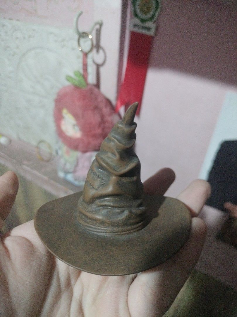 Harry Potter Sorting Hat Figurine Collectible (Category: Figurines & Statues) located in Paranaque City. Submitted by chechein_shop (Listing ID 1470966853, Image 3). Description: - Official Warner Bros Harry Potter Sorting Hat figure - Detailed brown textured design with a compact, palm-sized build - Features speaker holes and a battery compartment on the back - Stamped with official copyright info on the bottom - Made in China - Perfect for Harr