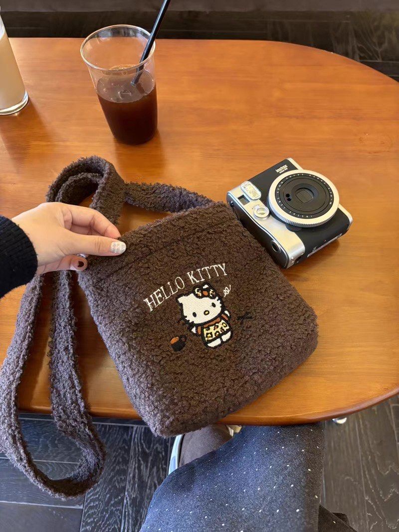 Hello Kitty brown fluffy crossbody bag with charm chain (Category: Cross-body Bags) located in Taguig. Submitted by mengxir20193848 (Listing ID 1471079338, Image 1). Description: - Super soft brown fleece exterior with durable fabric lining - Features cute Kitty embroidery on the front - Detachable silver chain strap adorned with multiple Kitty character charms - Secure zipper closure to keep your essentials safe - Long shoulder strap attached fo